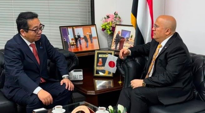 Yemen's Ambassador to Japan Adel al-Sunaini talks with Japanese lawmaker Tanaka Masashi in a Tokyo office, with Yemeni and Japanese flags on display
