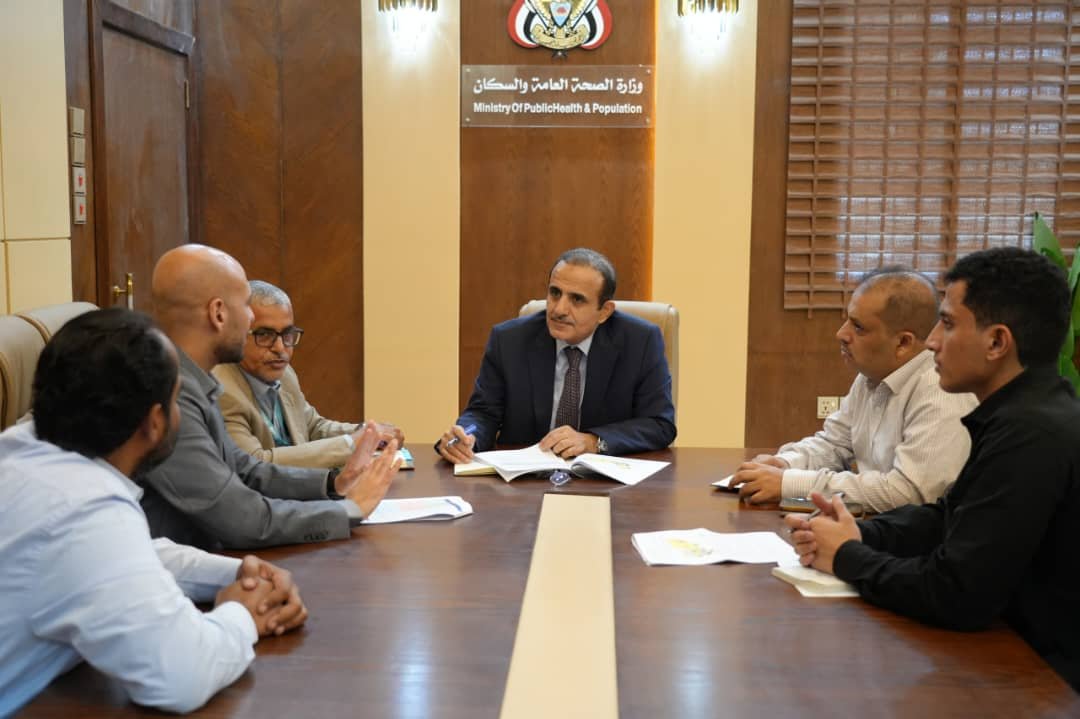 Yemen's Minister of Public Health and Population Dr. Qasem Buhaibeh meets a World Health Organization emergency medicine consultant at a ministry table in Aden