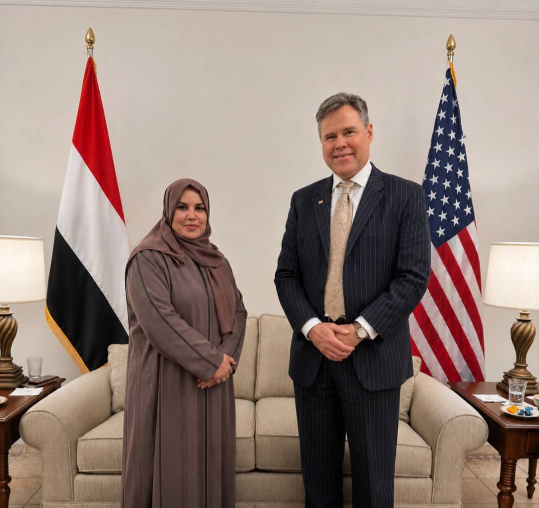 Yemen's Minister of State for Women's Affairs Dr. Ahed Jaassous stands with US Chargé d'Affaires Neil Hop in front of the Yemeni and American flags after their meeting in Riyadh.