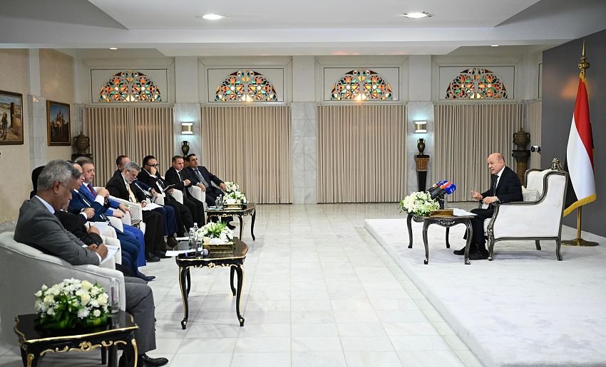 President Rashad al-Alimi addresses senior Yemeni officials and media representatives seated in a government meeting hall flanked by Yemeni flags