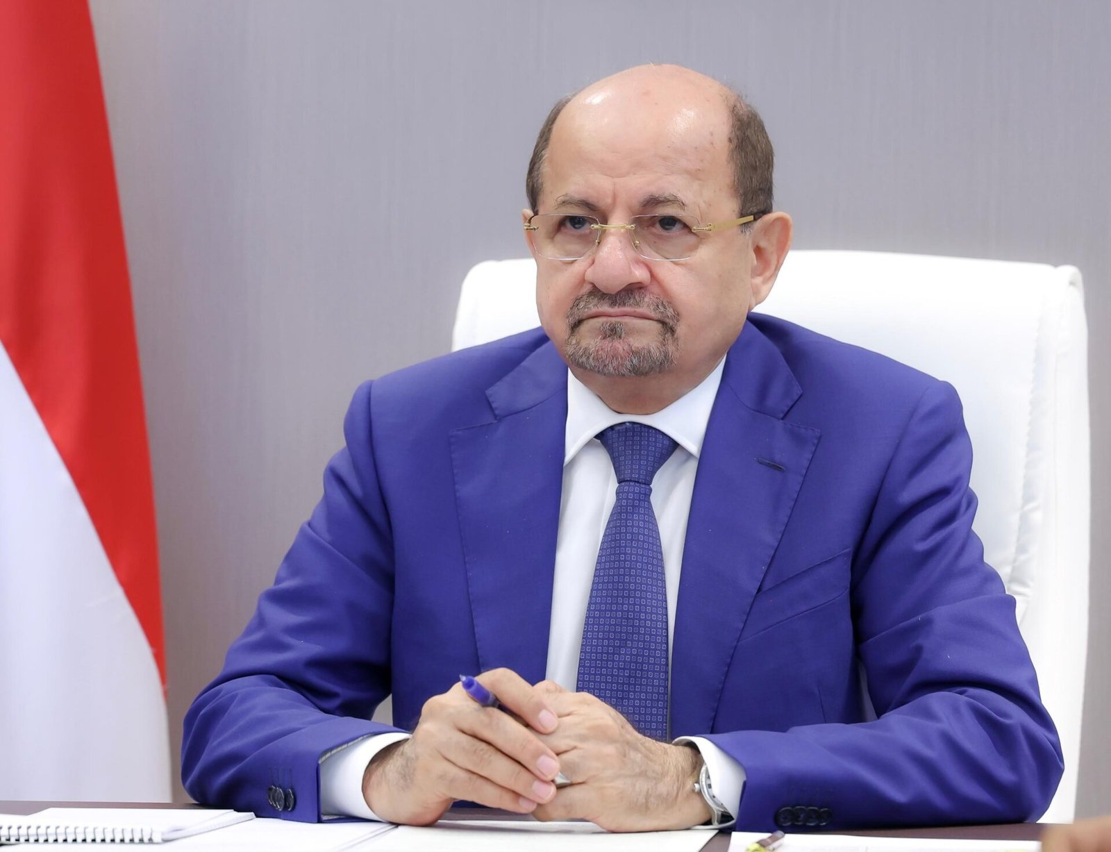 Yemeni Prime Minister Shaya Mohsen al-Zindani seated at his desk beside the Yemeni flag