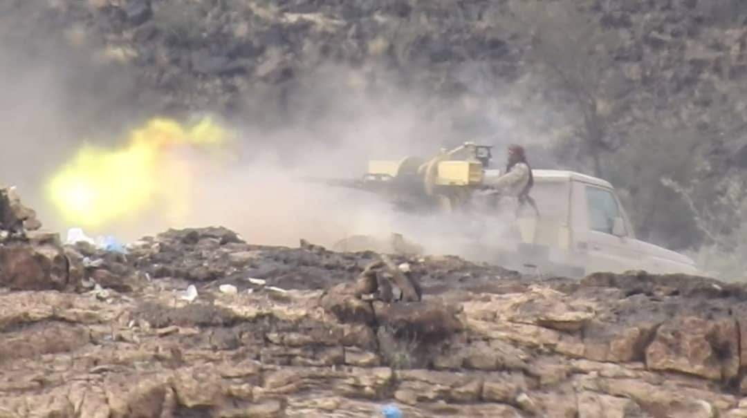 Yemeni government fighters firing a heavy weapon from a pickup truck on a rocky front line in Taiz governorate