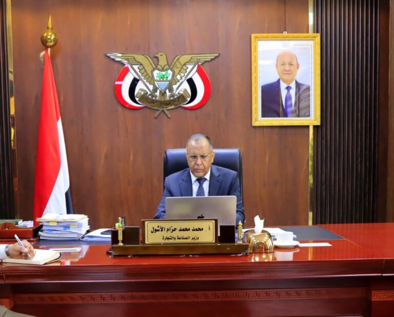 Yemen's minister of industry and trade, Mohammed al-Ashwal, seated at his desk in Aden during a video-conference session
