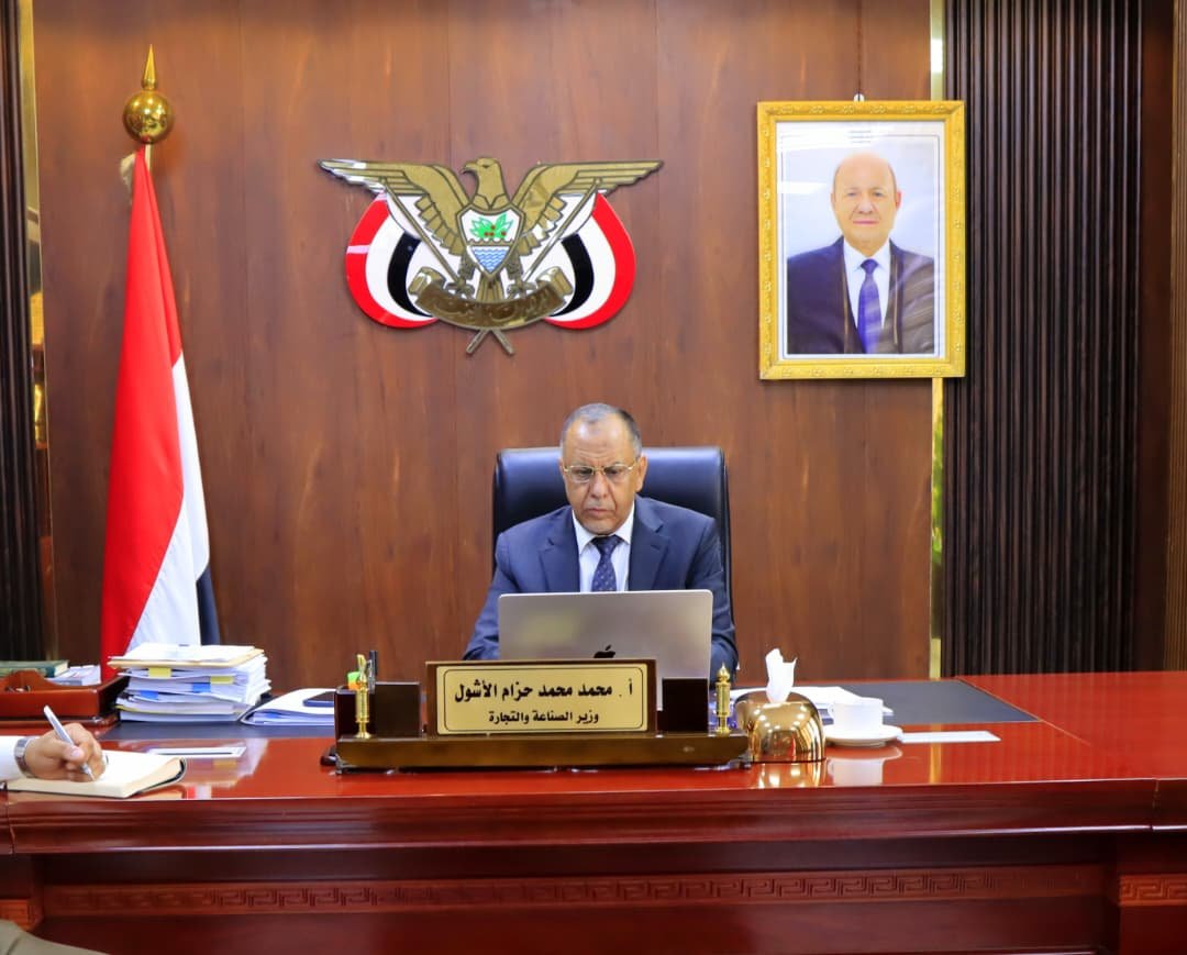 Yemen's minister of industry and trade, Mohammed al-Ashwal, seated at his desk in Aden during a video-conference session