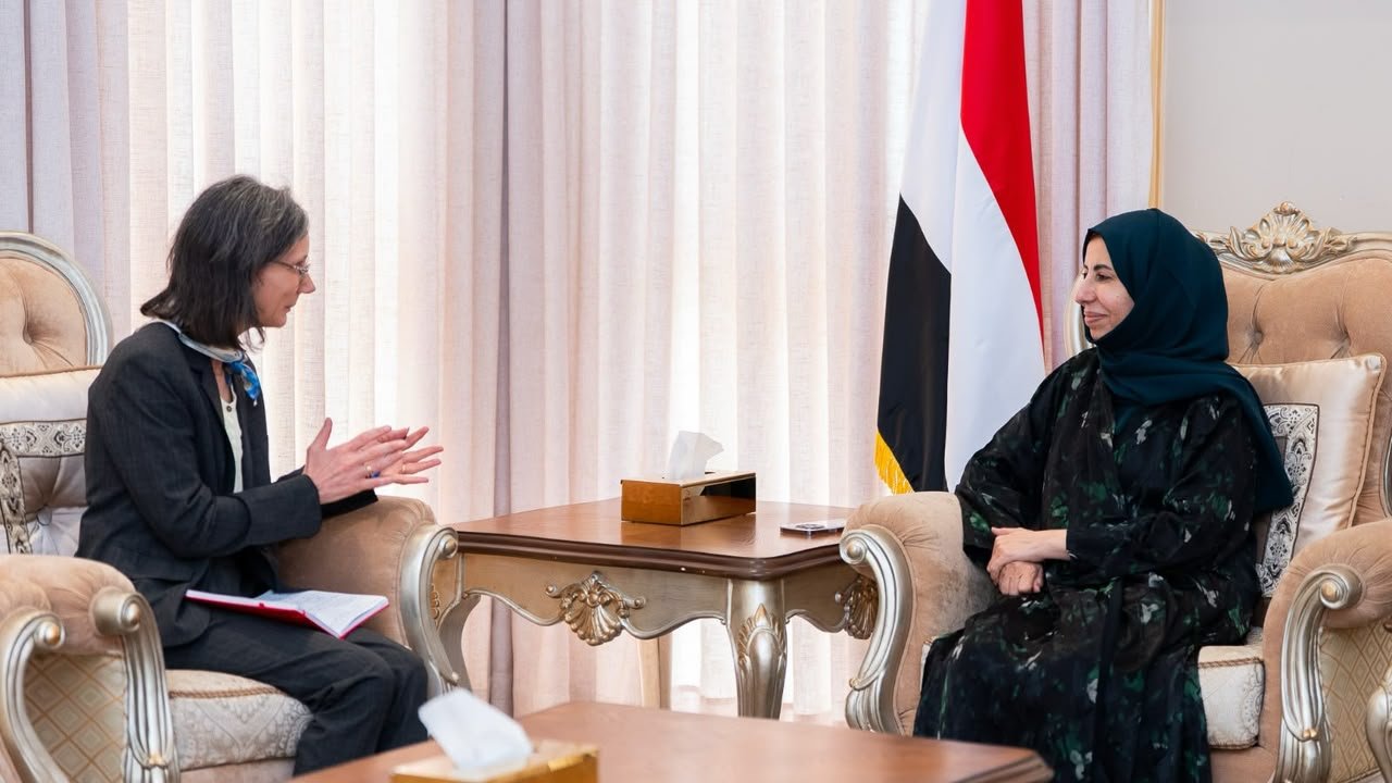French Ambassador Catherine Corm Cammoun in conversation with Yemeni Foreign Minister Afrah al-Zouba, the Yemeni flag behind them