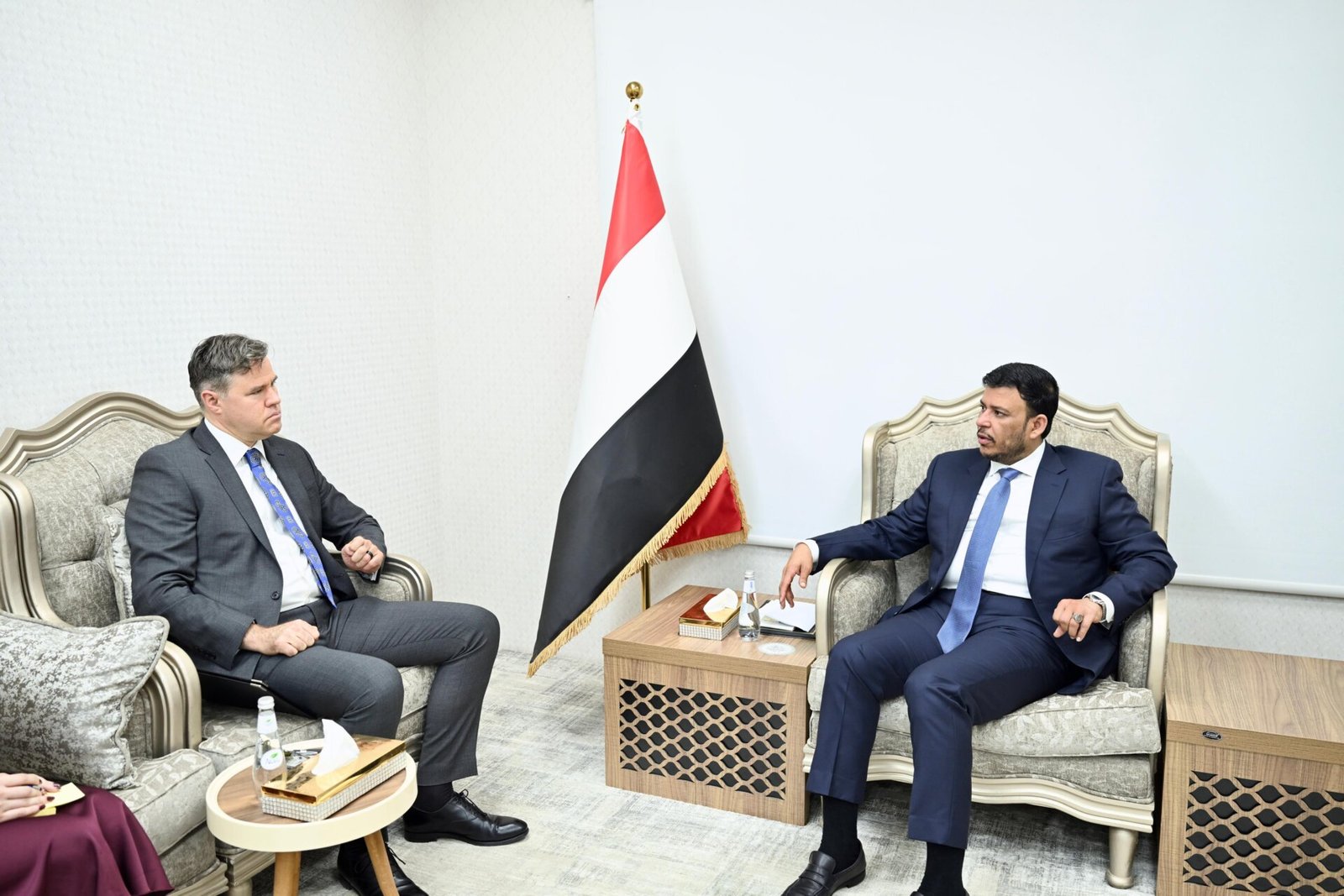 Yemeni Presidential Leadership Council member Abdullah al-Alimi Bawazir seated opposite U.S. chargé d’affaires Neil Hop beside a Yemeni flag in Riyadh.