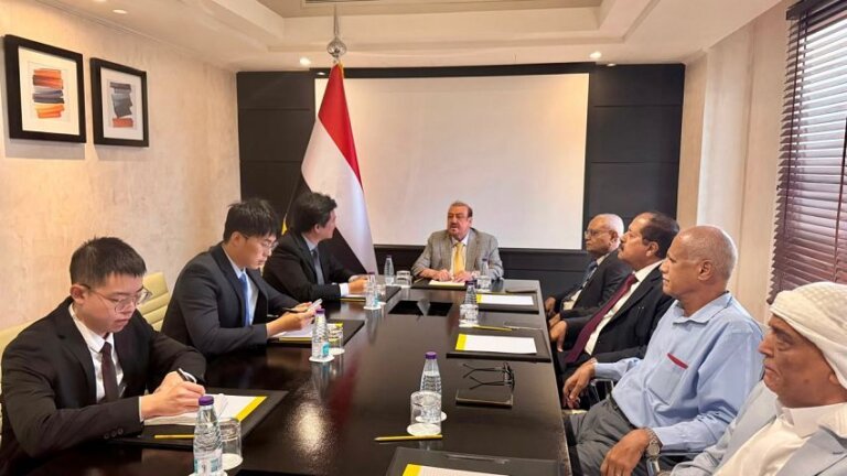 Yemen's parliament speaker Sultan al-Barakani meets Chinese embassy officials at a conference table beside the Yemeni flag.