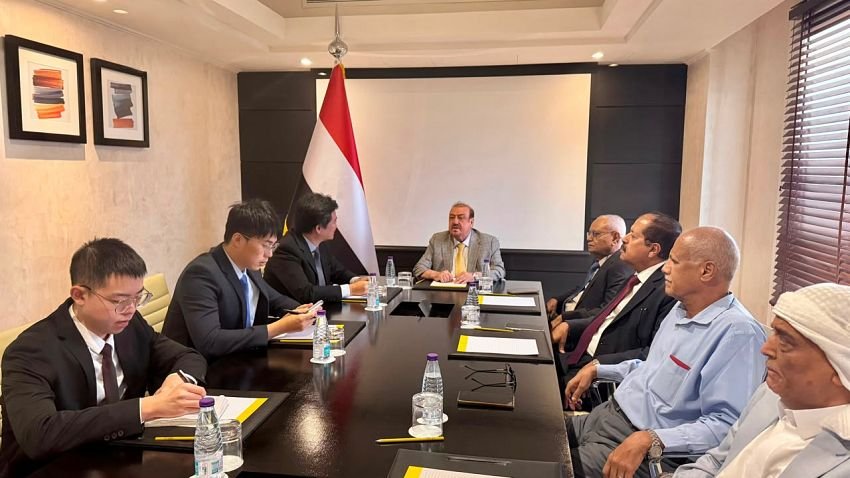 Yemen's parliament speaker Sultan al-Barakani meets Chinese embassy officials at a conference table beside the Yemeni flag.
