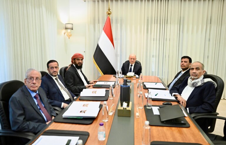 Members of Yemen’s Presidential Leadership Council seated around a conference table beside the Yemeni flag during a meeting chaired by Rashad al-Alimi