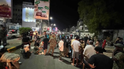 Protesters gather at night during a demonstration in Aden, Yemen