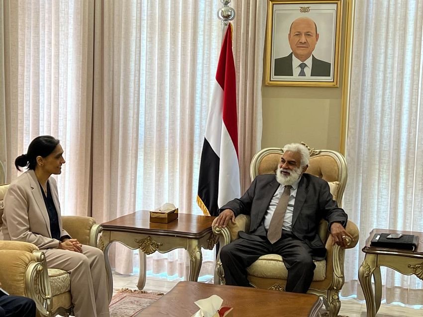 Yemen’s minister of planning and international cooperation meets the United Kingdom’s ambassador to Yemen in a formal office, seated beneath the Yemeni flag.