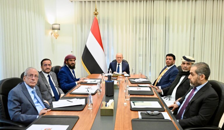 Members of Yemen’s Presidential Leadership Council and cabinet ministers seated around a table beside the Yemeni flag during a joint meeting