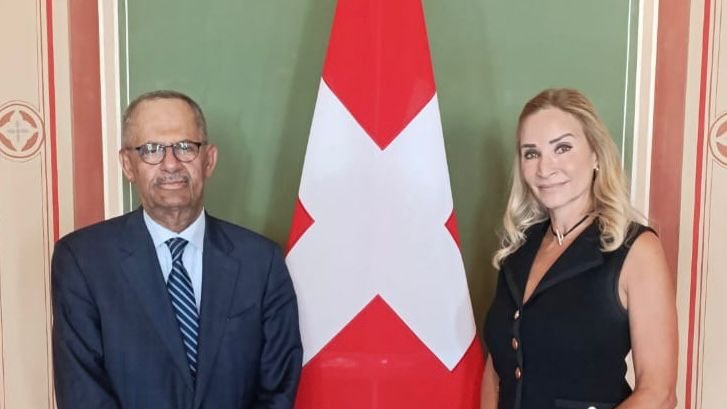 Yemen's ambassador Ali Mujawar meets Swiss foreign ministry official Monika Schmutz Kirgoz beside a Swiss flag in Geneva