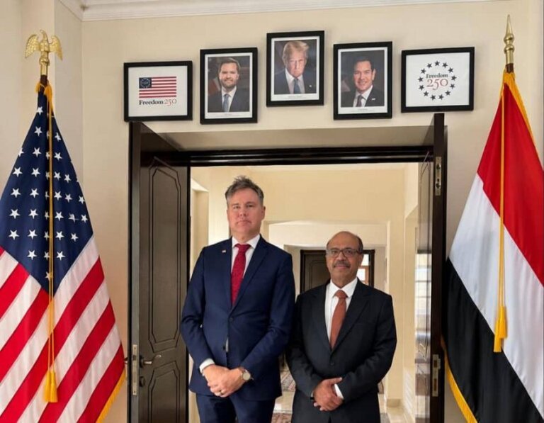 Yemen’s oil minister and the acting US ambassador stand between the American and Yemeni flags at the US mission.