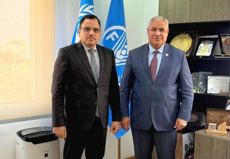 Yemen’s agriculture minister and an FAO regional representative stand together beside the organisation’s emblem