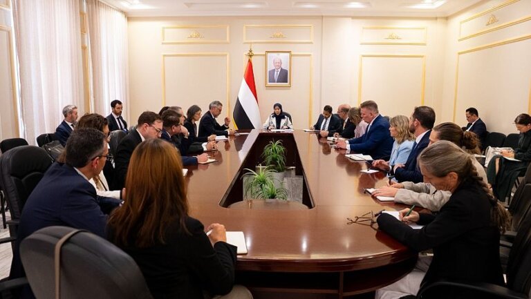 Yemeni Foreign Minister Afrah al-Zouba meets European Union ambassadors around a conference table beneath a Yemeni flag