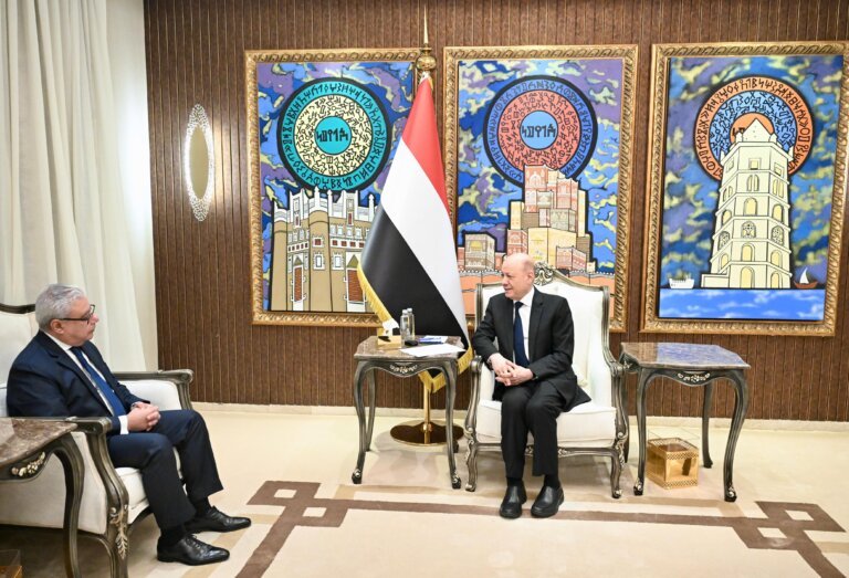 Rashad al-Alimi receives Egypt's departing ambassador Ihab Ahmed Abu Srie in a reception room with the Yemeni flag