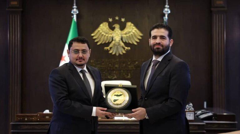 Yemeni acting ambassador Mohammed Baaker and Syrian Interior Minister Anas Khattab exchange a commemorative plaque during a meeting at the Interior Ministry in Damascus
