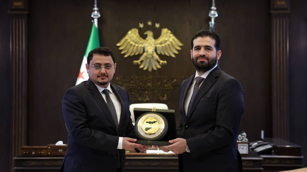 Yemeni acting ambassador Mohammed Baaker and Syrian Interior Minister Anas Khattab exchange a commemorative plaque during a meeting at the Interior Ministry in Damascus