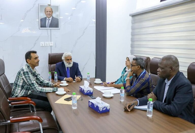 Yemen's planning minister Mohammed al-Faqmi meeting UN humanitarian officials at a table in Aden to discuss displacement response