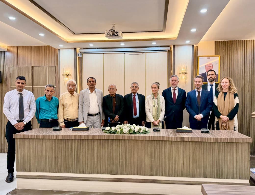 Yemeni and European officials stand behind a conference table after talks on agriculture and fisheries cooperation in Aden