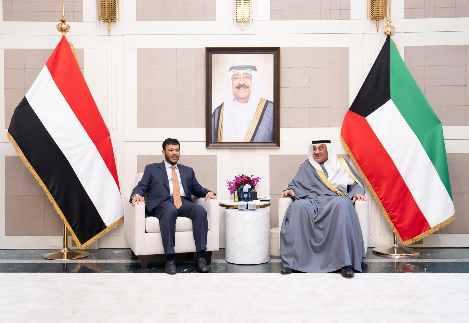 Yemeni Presidential Leadership Council member Abdullah al-Alimi Bawazir seated with Kuwaiti Crown Prince Sheikh Sabah Khaled al-Hamad al-Sabah beneath the Yemeni and Kuwaiti flags in New York
