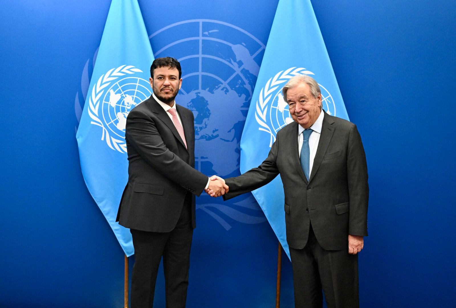 Abdullah al-Alimi Bawazir shakes hands with UN Secretary-General António Guterres in front of United Nations flags in New York