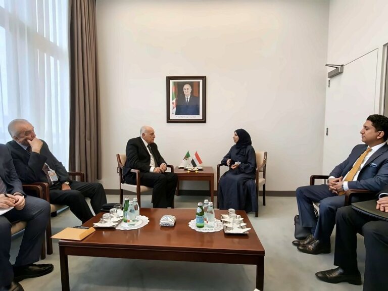 Yemeni Foreign Minister Afrah al-Zouba and Algerian Foreign Minister Ahmed Attaf seated for talks with Yemeni and Algerian table flags between them