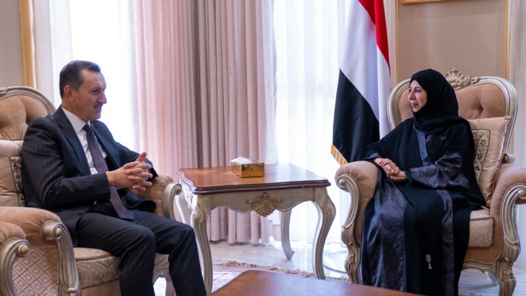 Yemeni Foreign Minister Afrah al-Zouba seated with Turkish envoy Emrullah Isler beside a Yemeni flag in Riyadh