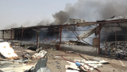 A wrecked, smouldering structure with smoke rising and debris scattered on the ground after strikes in the Mokha port area on Yemen's Red Sea coast.