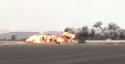 An explosion sending flame and a plume of black smoke into the air over open ground in Yemen