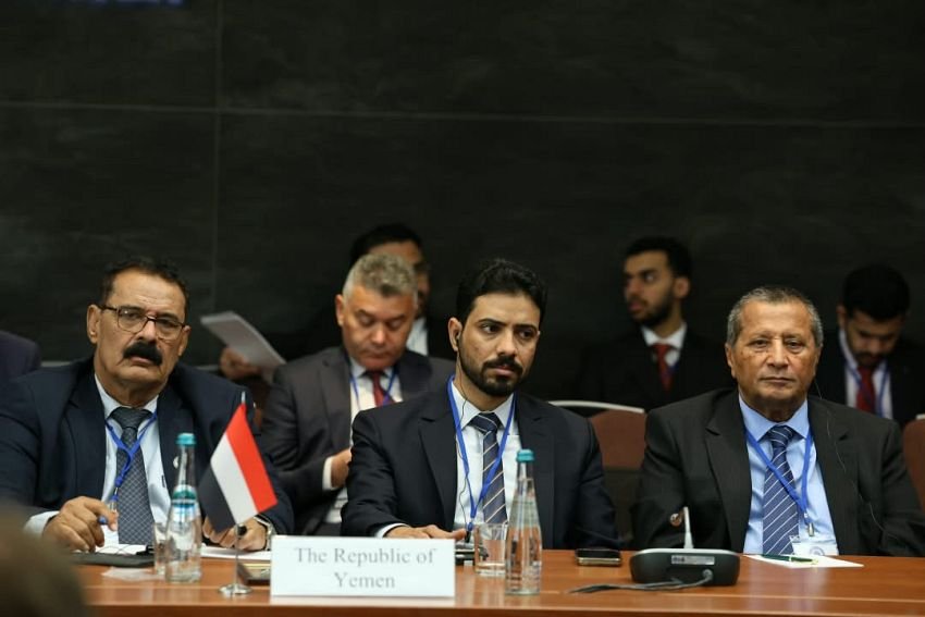 Members of the Yemeni delegation seated behind a Republic of Yemen nameplate and flag at an international conference table