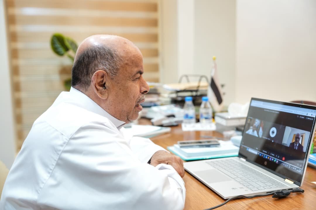 Salem al-Khanbashi seated at his desk taking part in a video conference call on a laptop