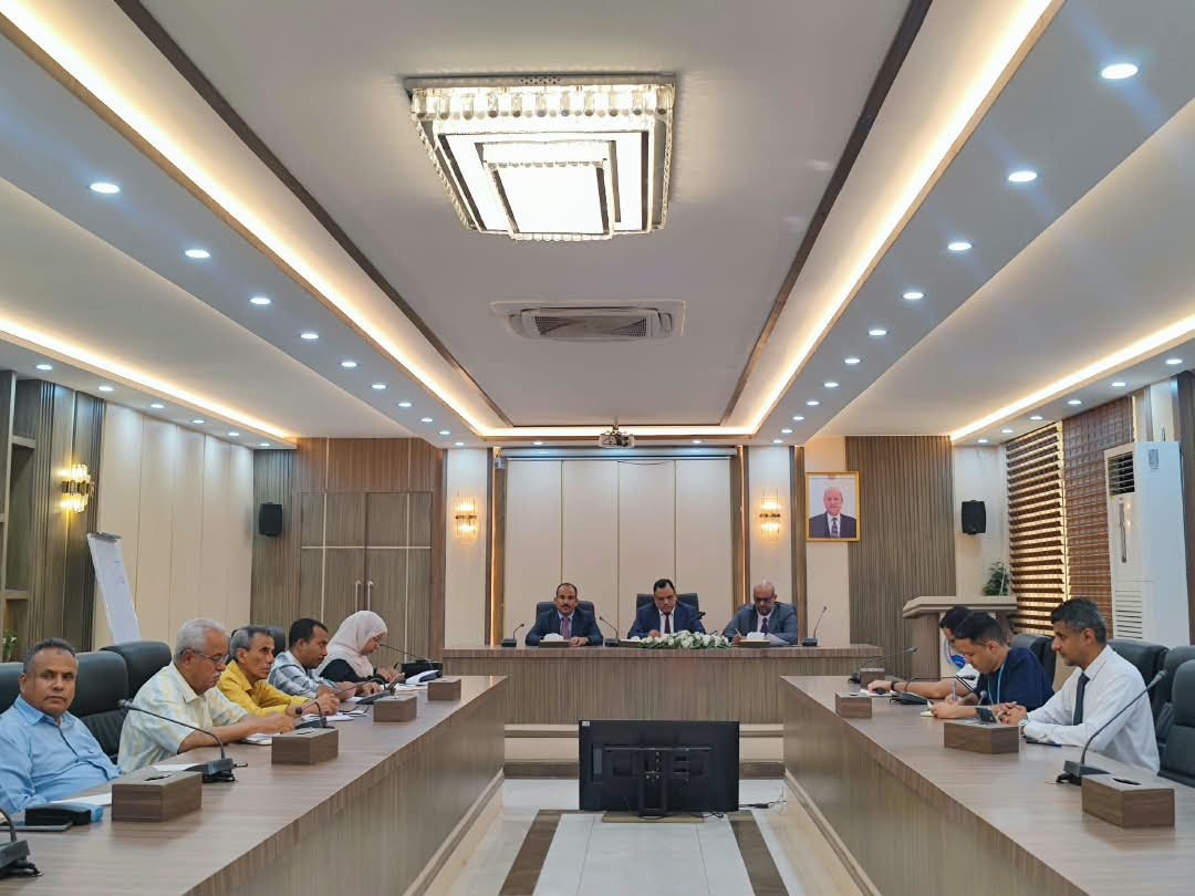 Yemeni officials seated around a conference table in a government meeting room in Aden during video-link talks