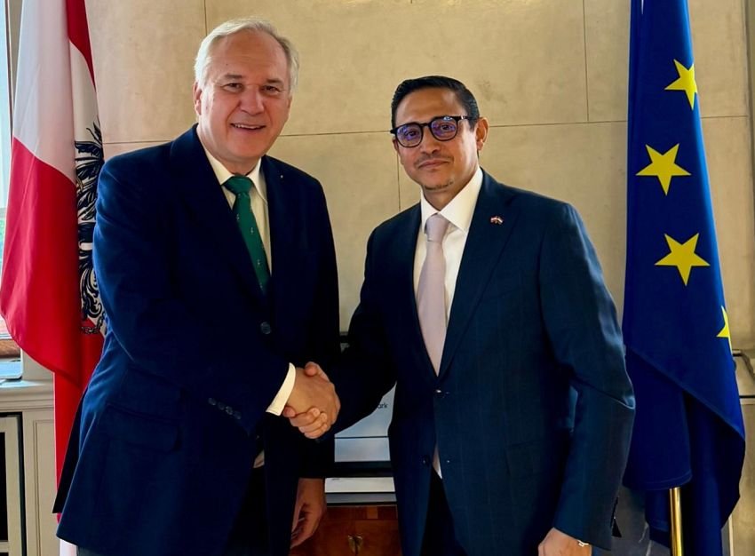 Yemeni Ambassador Haitham Shujaaldeen shakes hands with Austrian Parliament President Walter Rosenkranz beside Austrian and European Union flags in Vienna