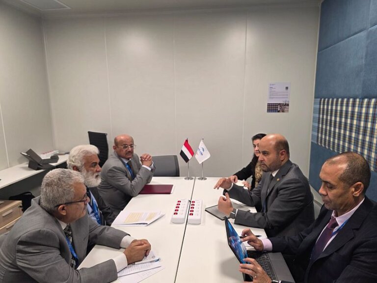 Yemeni officials seated at a meeting table beside a Yemeni flag during talks on the sidelines of the IMF and World Bank annual meetings