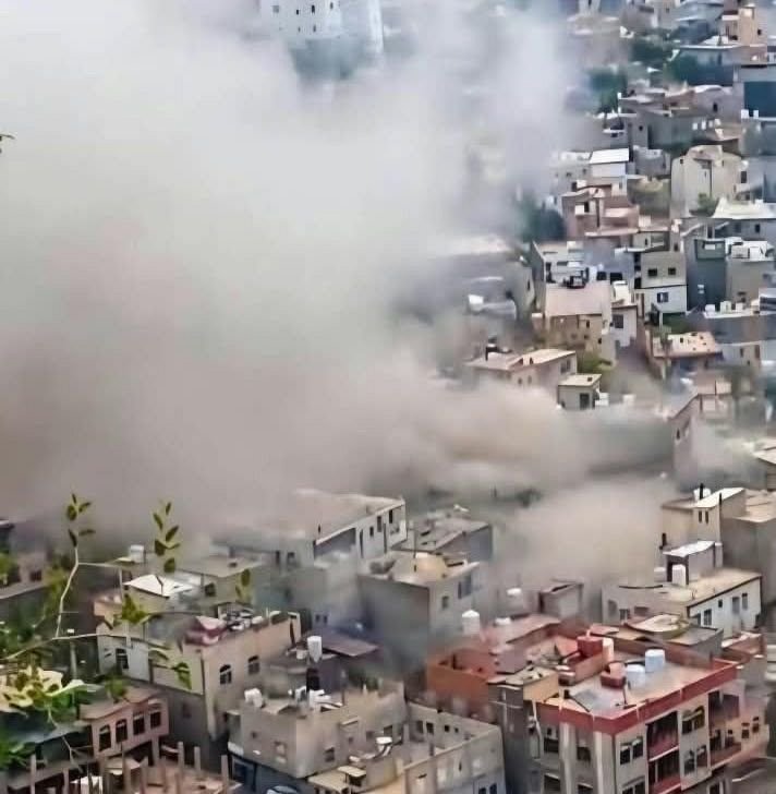 Smoke and dust rise over damaged buildings in a densely populated district of central Taiz, Yemen
