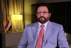 A Yemeni official seated before the national flag during a recorded statement on the Shabwa training camp attack.