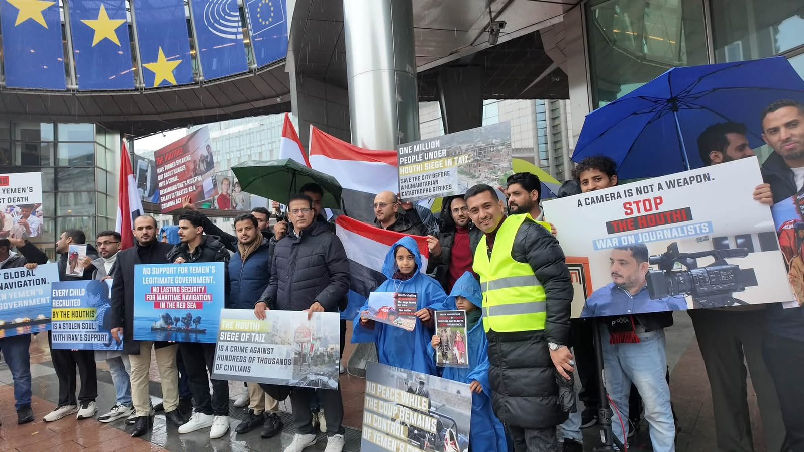Yemeni demonstrators hold placards and flags outside the European Parliament in Brussels calling for an end to the siege of Taiz