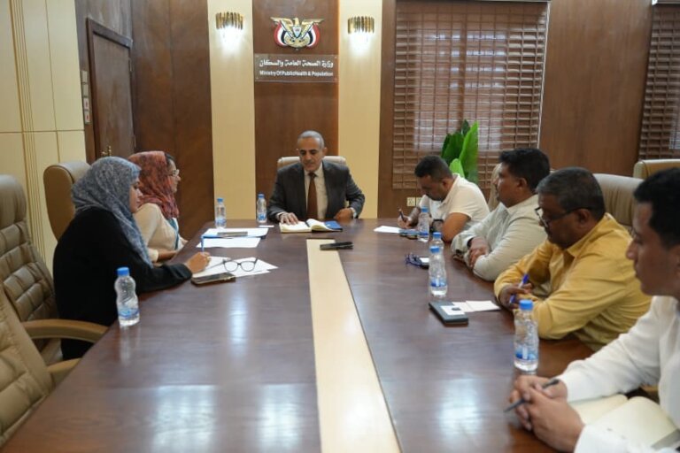 Yemeni health ministry and World Food Programme officials seated at a meeting table beside Yemeni flags in Aden