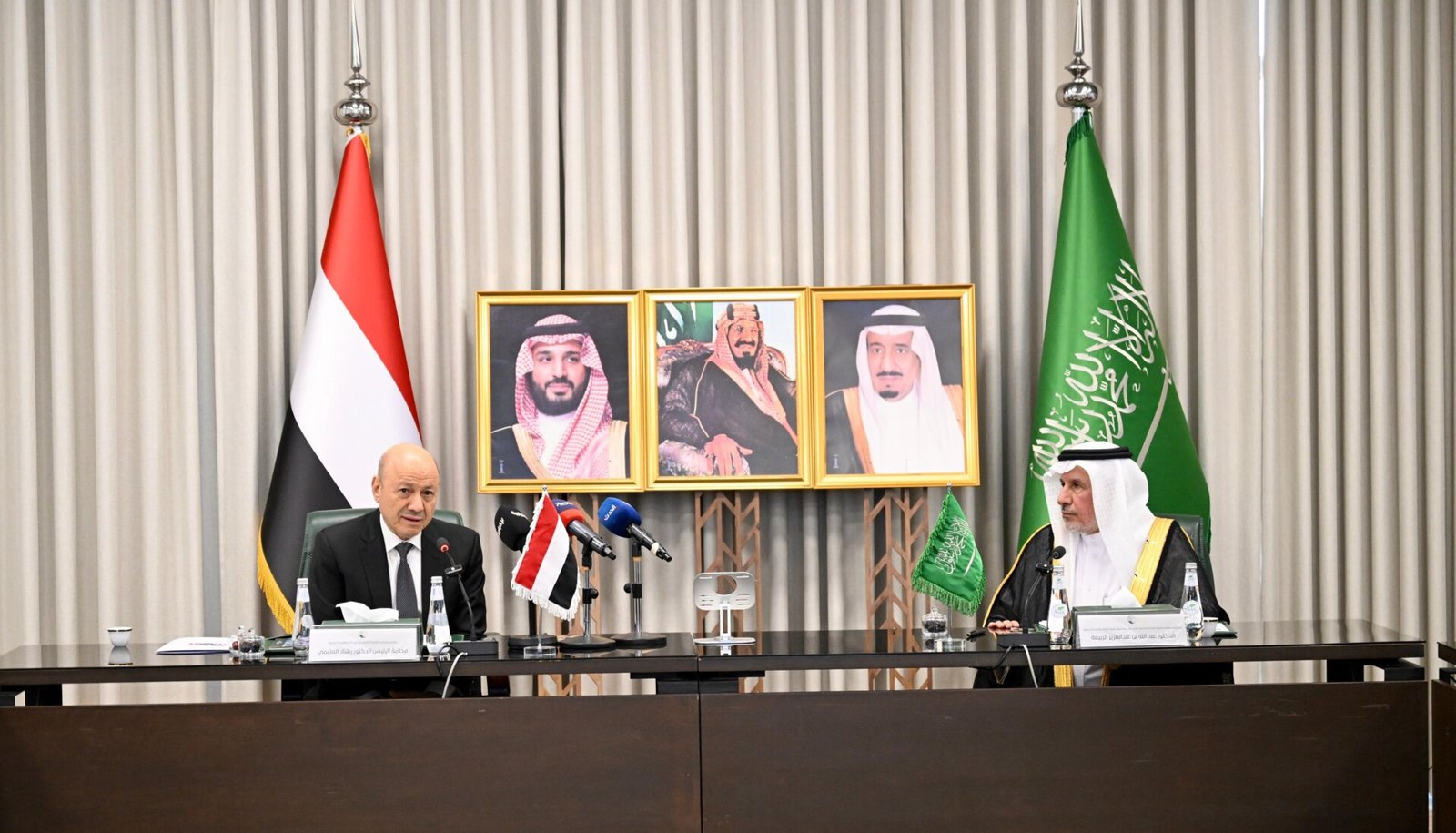 Rashad al-Alimi seated with Saudi officials between Yemeni and Saudi flags during his visit to the King Salman relief centre in Riyadh