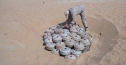 Munitions and unexploded ordnance laid out on the ground before a controlled destruction by Masam demining teams in Yemen