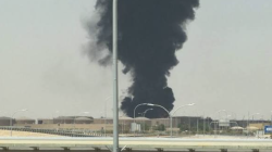 A large plume of black smoke rises over an industrial facility in Riyadh, Saudi Arabia
