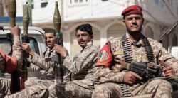 Yemeni soldiers in camouflage stand with assault rifles at a front-line position