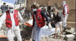 Red Crescent workers in protective suits recover remains from a collapsed building in Yemen
