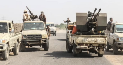 Armed pickup trucks with mounted guns on a road in Yemen
