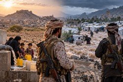 Armed men stand above a camp in Yemen as displaced families fill water containers
