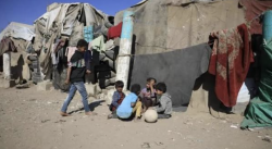 Displaced Yemeni children sit outside makeshift tents at a camp for families uprooted by the conflict