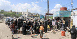 Displaced Yemeni families queue with water containers at a distribution point