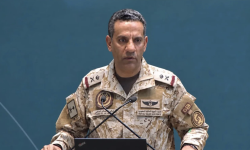 A Saudi-led coalition military spokesman speaks at a podium during a news briefing.